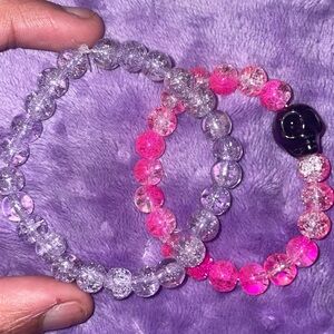 Pink acrylic , with black skull . Comes with 2 separate bracelets